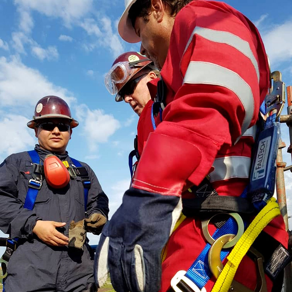 Personal con equipo de protección y arneses en una actividad exterior.
